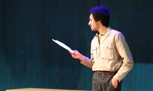 Man reading a script on stage.