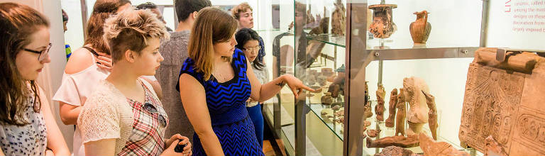 students looking at artefacts in museum