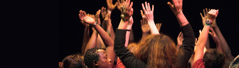 drama students with arms in the air