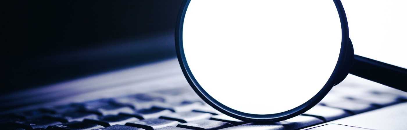 Magnifying glass on a computer keyboard.